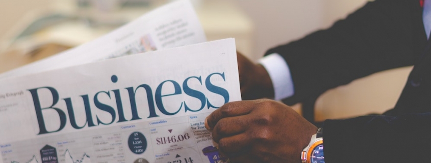 Blog header image of a businessman reading the business news for 13 recommended CPM software tools for effective KPI management blog from Solver